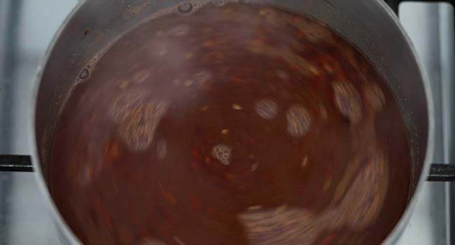 whisking together a vinegar bbq sauce in a pot
