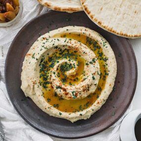 plate of swirled homemade hummus with olive oil and parsley