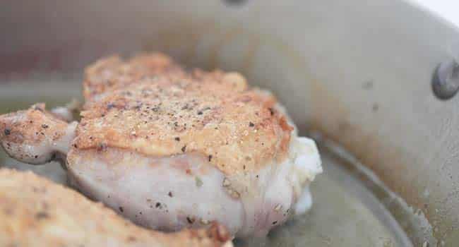 searing chicken in a pan with oil