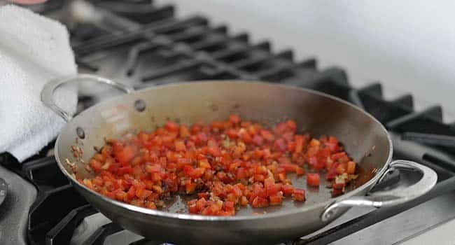 cooking a sofrito in a paella pan