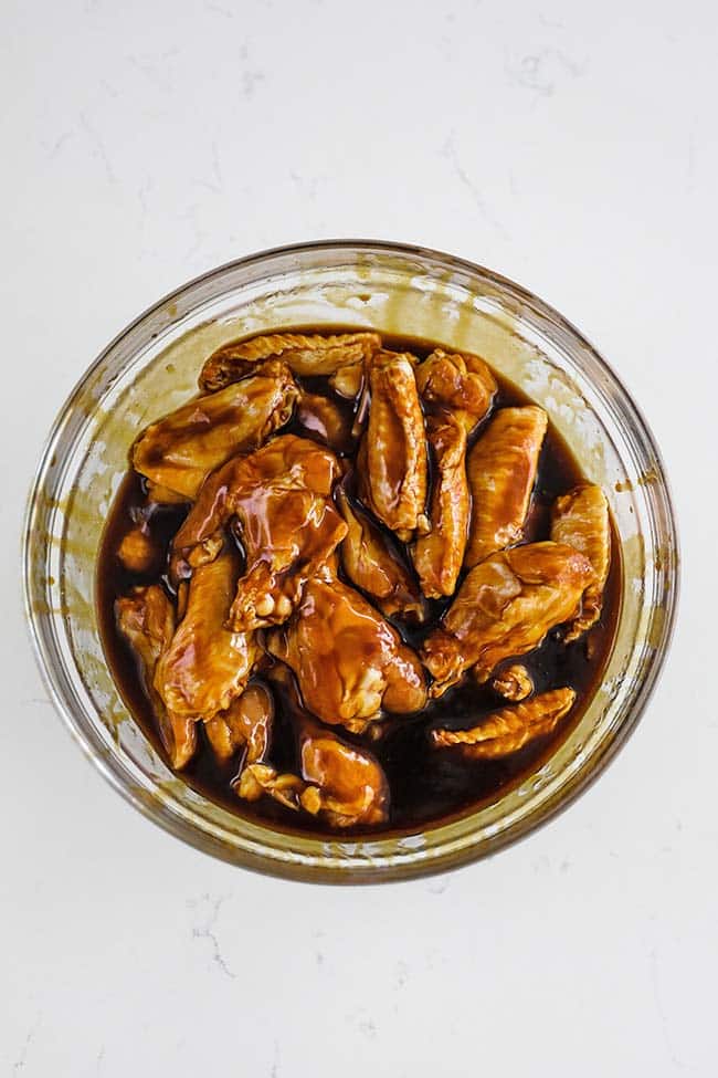 chicken wings marinating in a hoison marinade in a bowl