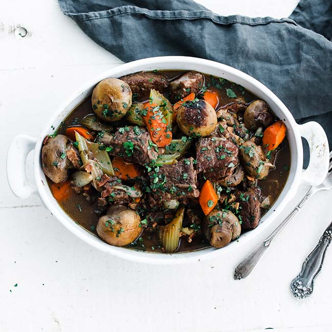 bowl of cubed beef with mushrooms and carrots