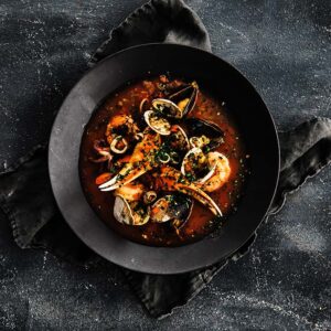 cioppino recipe in a plate with a tomato broth and seafood