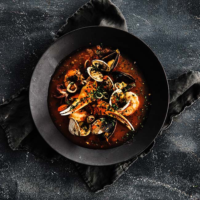 cioppino recipe in a plate with a tomato broth and seafood