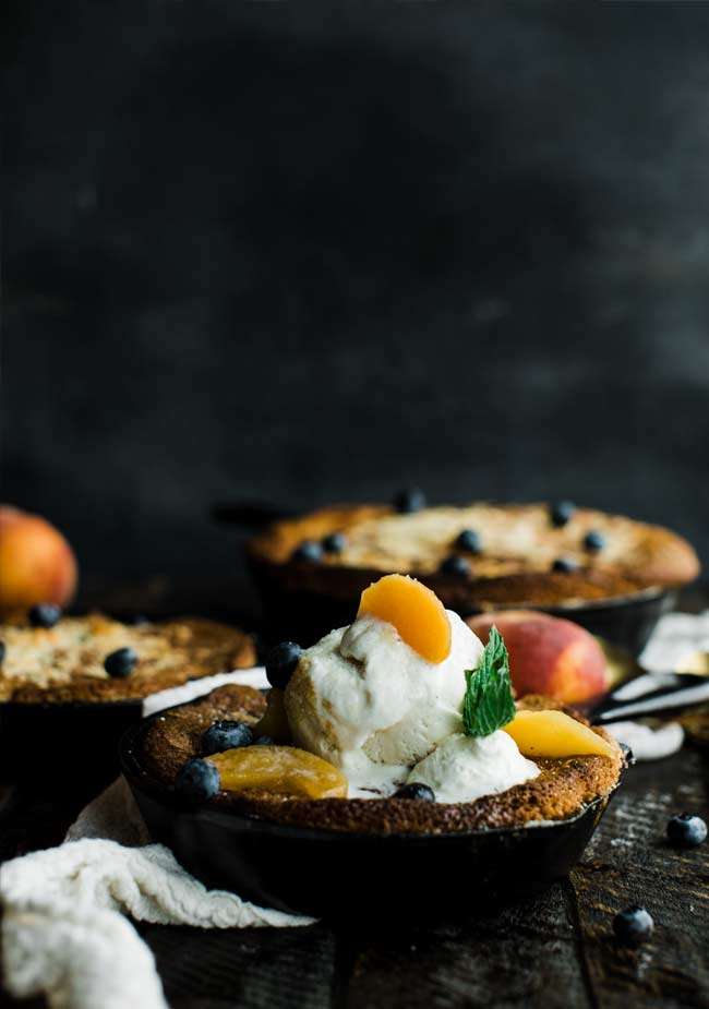 3 cast iron skillets with peach cobbler in them