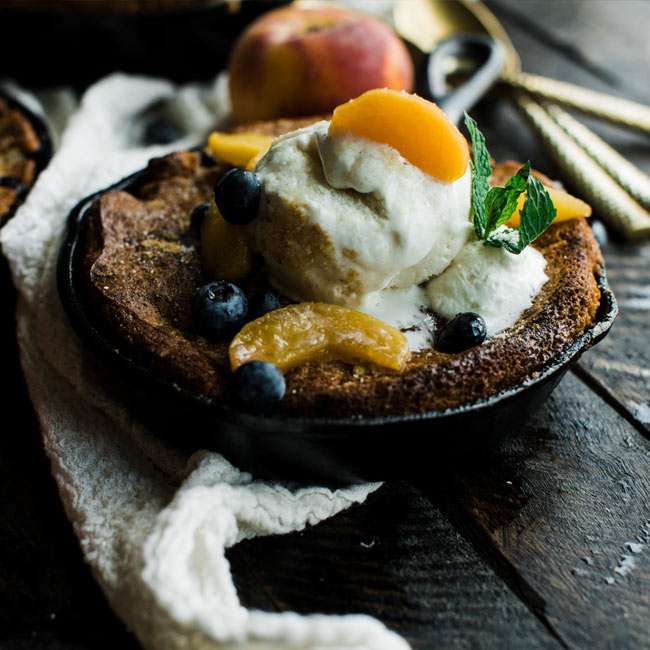 skillet peach cobbler recipe with ice cream and whipped cream