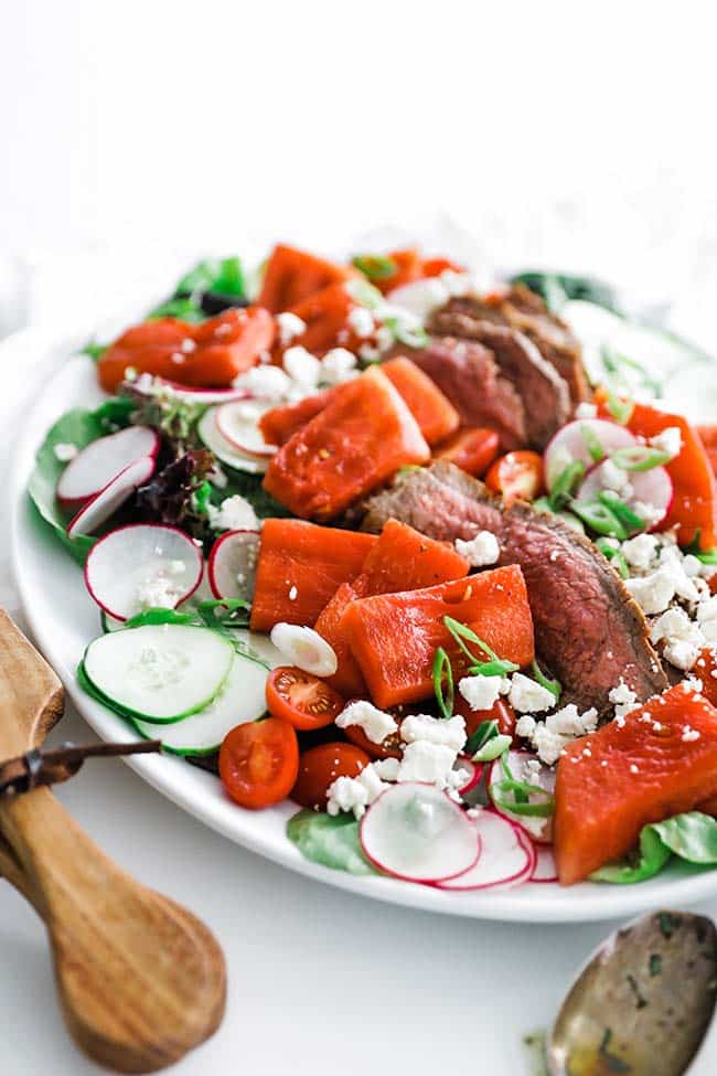 grilled watermelon and steak on a greens salad with vegetables