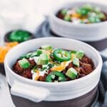 chili with flank steak and beans served with assorted toppings