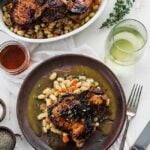 a plate of pork and beans with wine and herbs