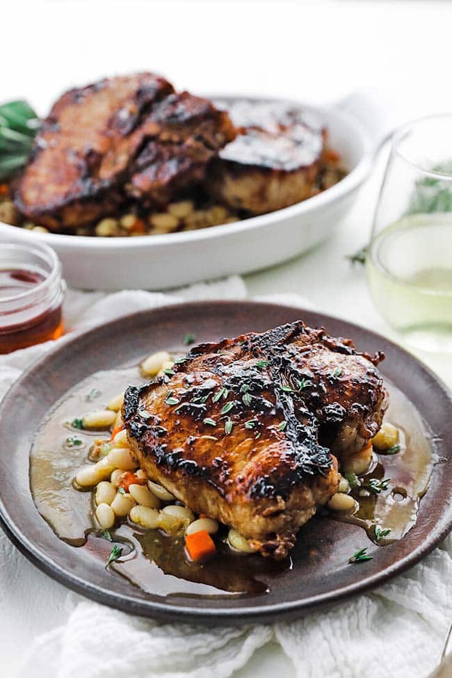 plate of roasted pork chops with white beans and vegetables