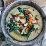 zuppa toscana with beans, kale, potatoes and parmesan cheese in a bowl