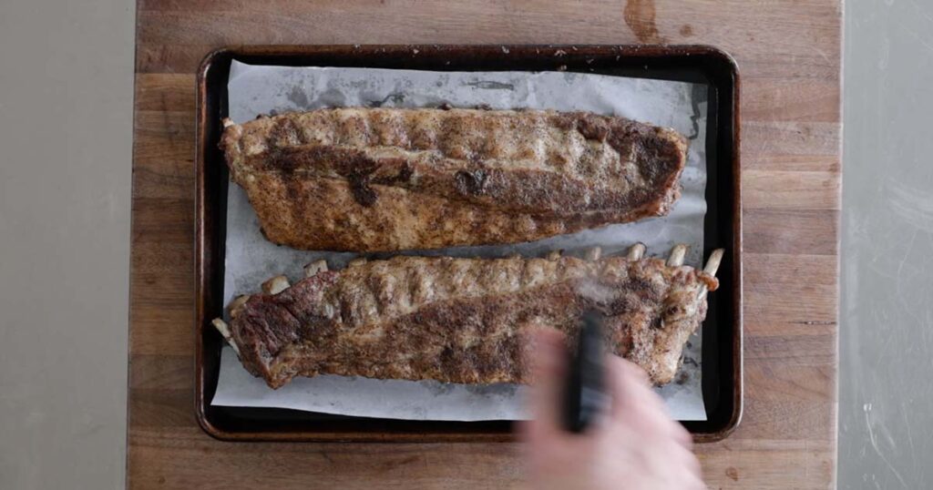 spraying cooked ribs with vinegar