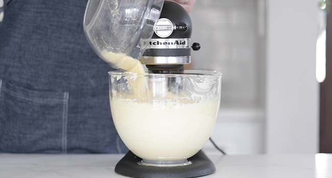adding dry ingredients to whipped butter in a stand mixer