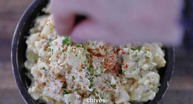 garnishing potato salad with chives