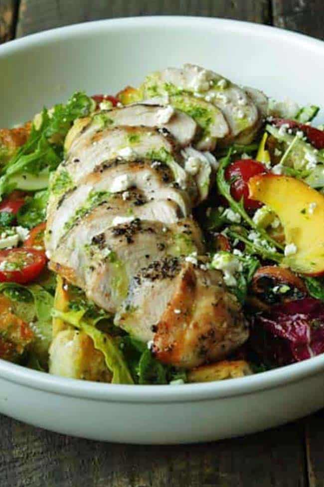 bowl of panzanella salad with grilled chicken and pesto vinaigrette