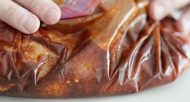 moving the seasoning around with pork tenderloin in a plastic zip bag