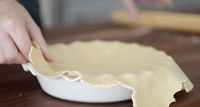 placing dough onto a pie pan