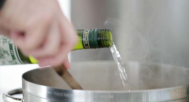 adding vermouth to a pot