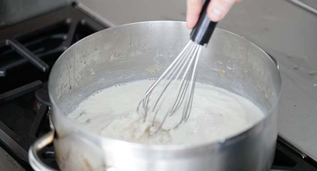 whisking cheese into a bechamel sauce