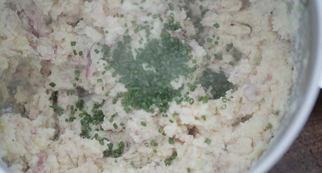 adding chives to mashed potatoes