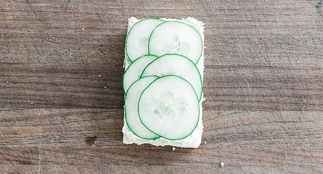 adding cucumbers to bread