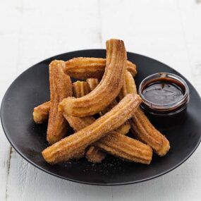plate of churros with chocolate sauce