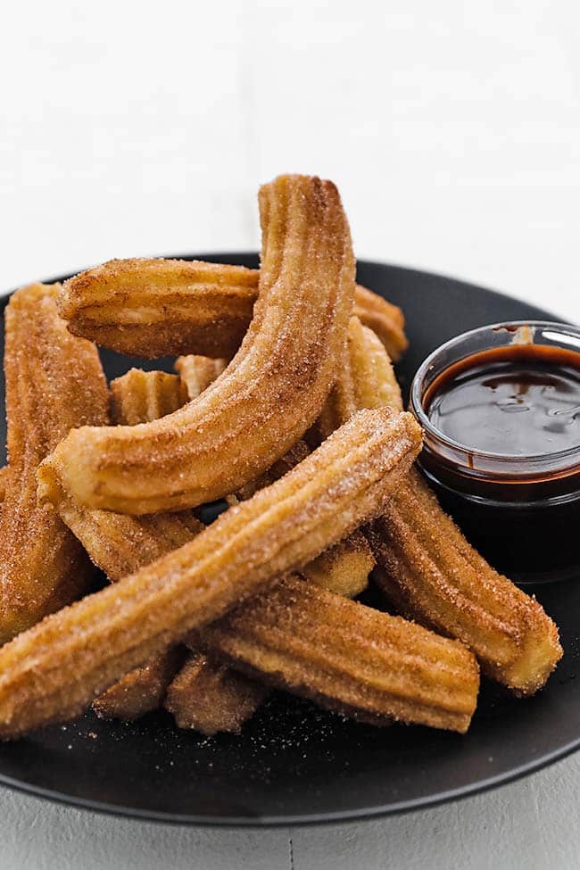 plate full of cinnamon and sugar churros