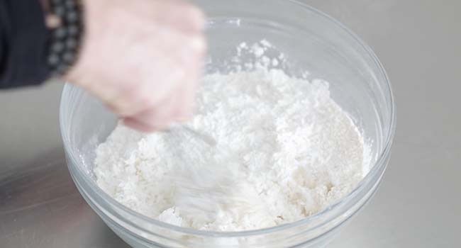 whisking flour and shredded coconut