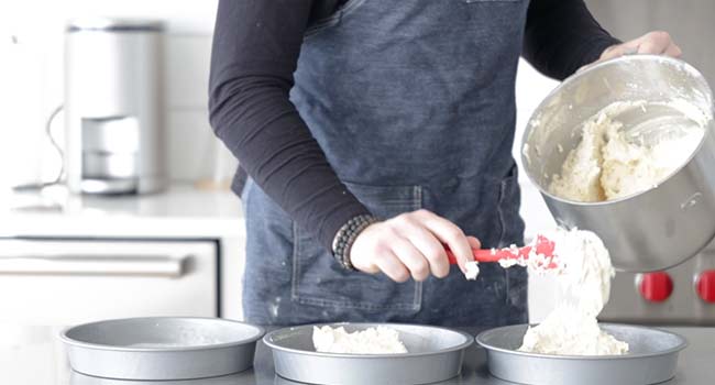 dividing coconut cake batter into pans