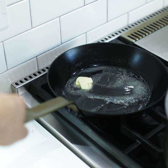 swirling around melted butter in a saute pan for cooked green beans