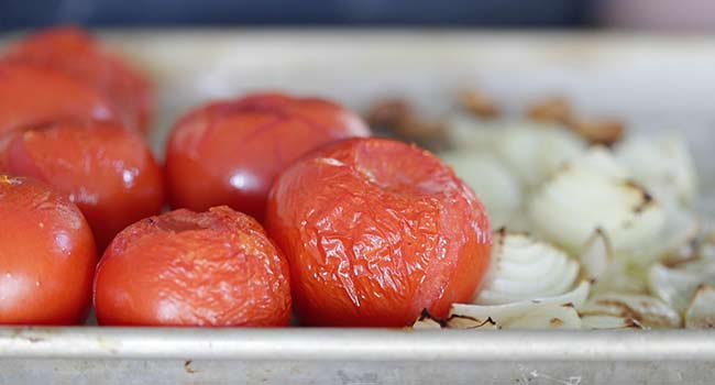roasted tomatoes and onions on a sheet tray