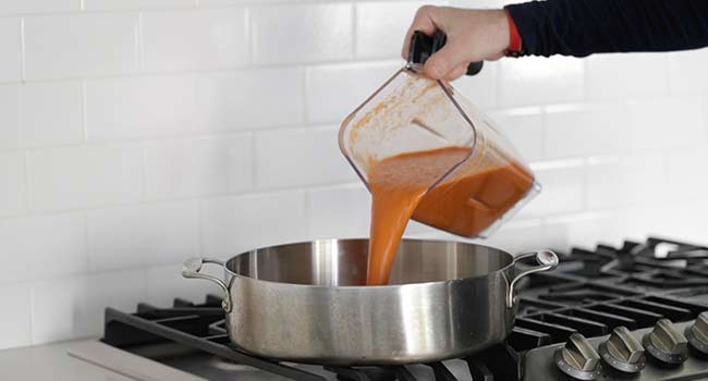 pouring a chilaquiles sauces in a rondeau pot