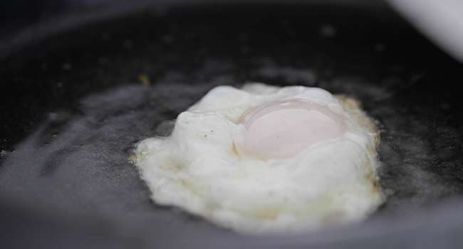 frying an egg in oil in a pan