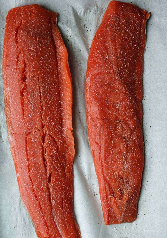 sides of salmon in parchment seasoned with salt and pepper