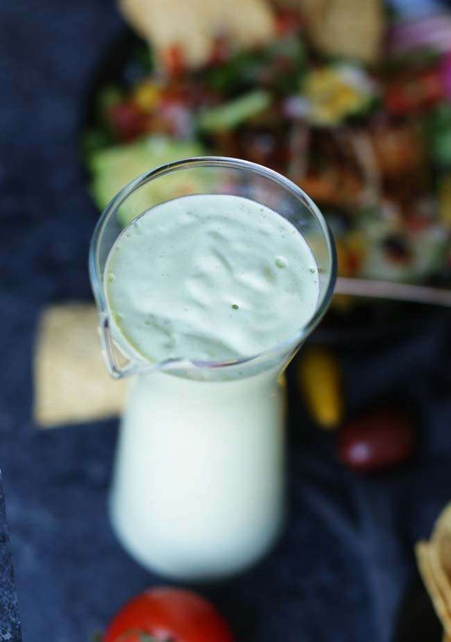 green avocado lime salad dressing in a pourable jar