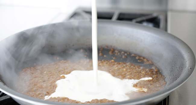 adding cream to a pan