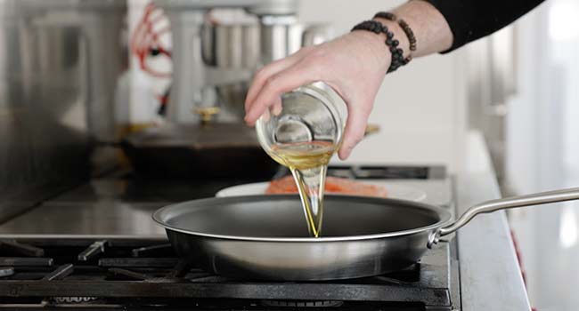 adding oil to a pan