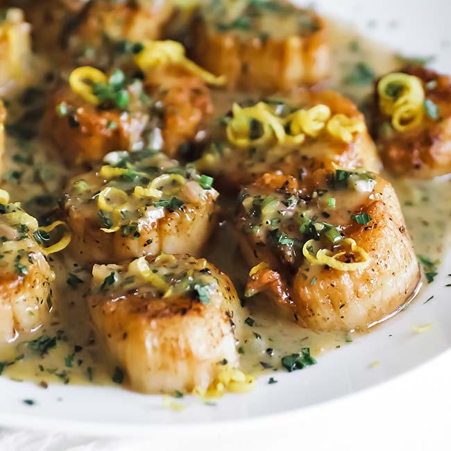 scallops with butter sauce on a plate