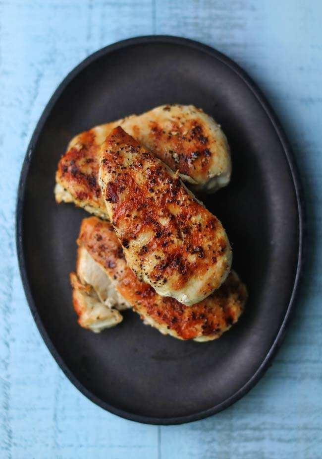 grilled chicken breasts on a cast iron plate