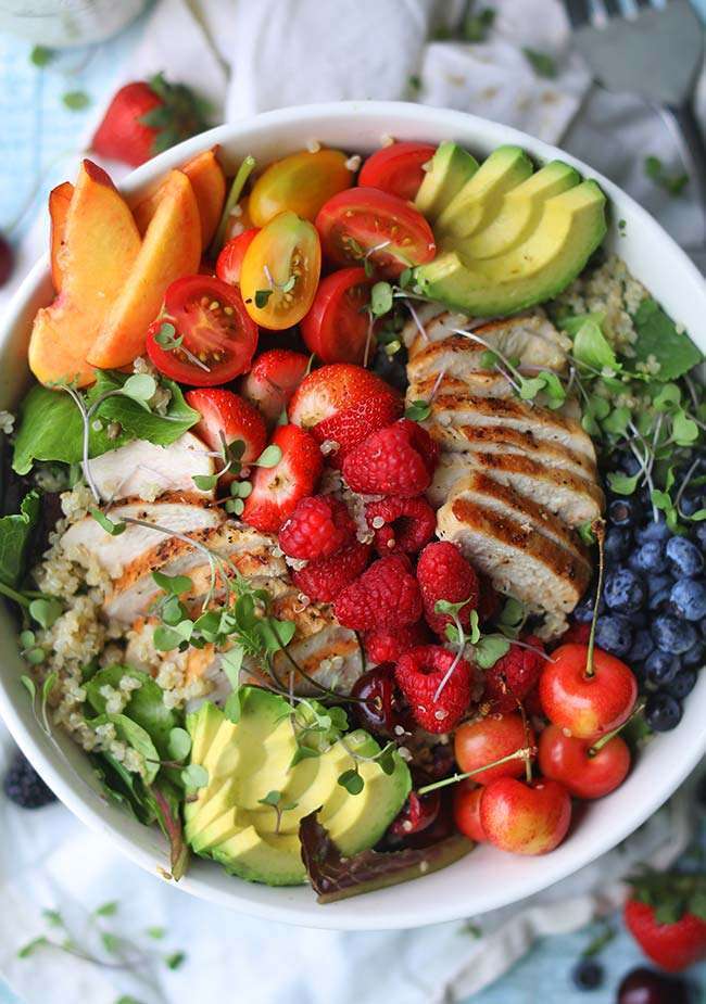 summer salad with fresh berries, cherries, peaches, avocados, chicken and quinoa