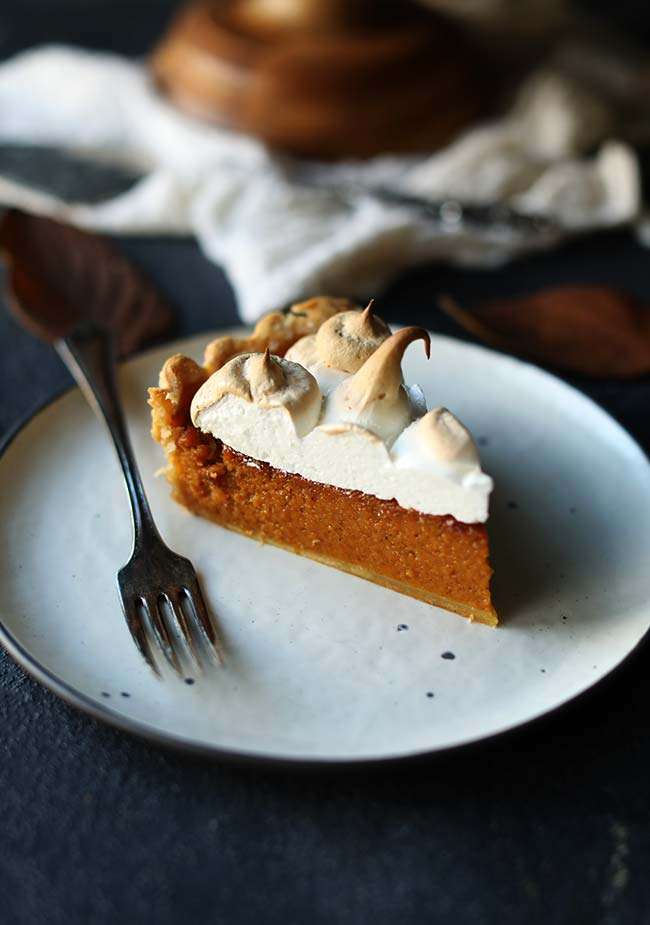 slice of sweet potato pie with marshmallow merengue on a small plate with a fork