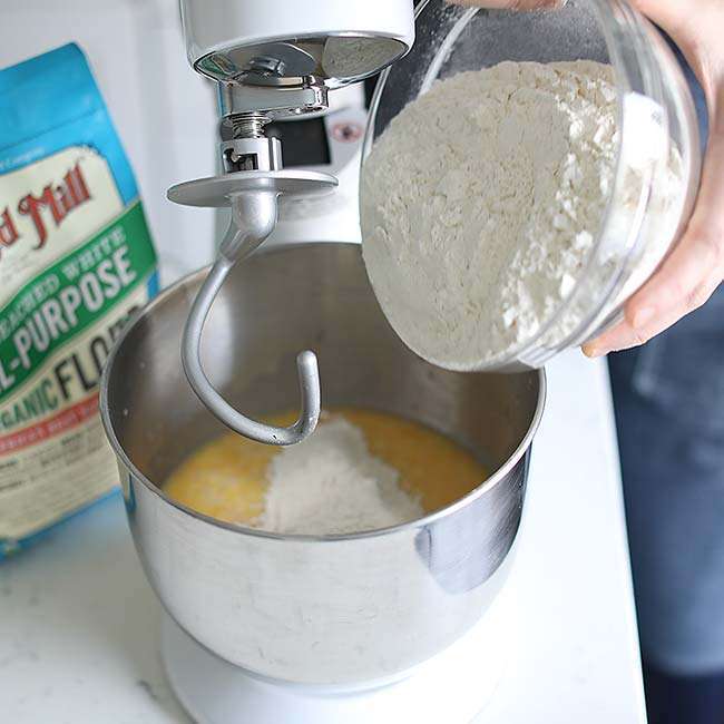 slowly adding in flour to a stand mixer with the paddle attachment
