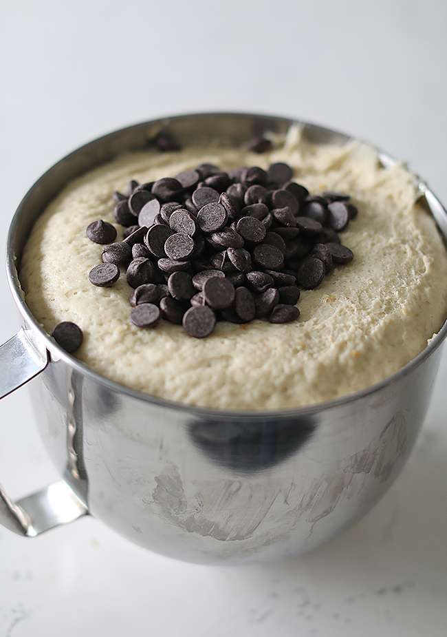 proofed bread in a stand mixer bowl with chocolate chips on top