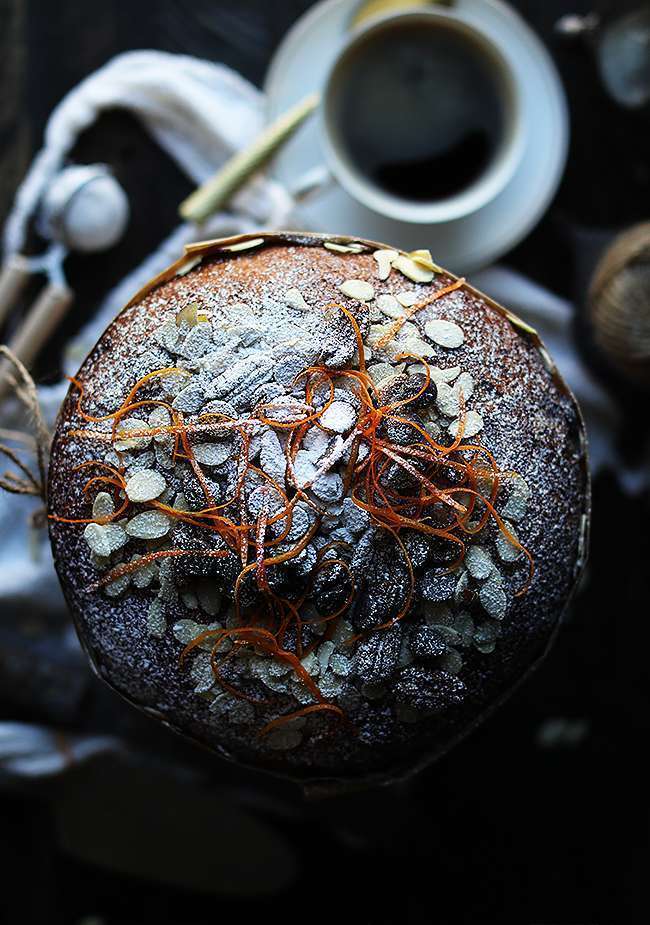 zest, powdered sugar and almonds on top of a panettone bread