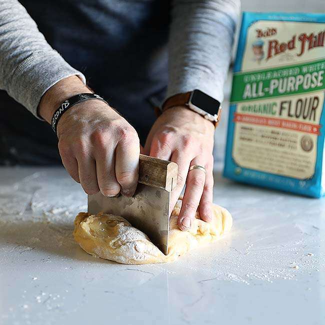 cutting dough into sections on a countertop