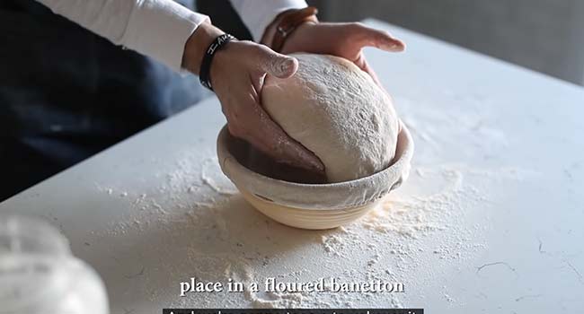 placing bread dough into a bannaton