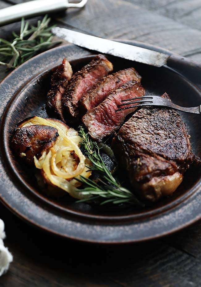 sliced new york strip steak with potatoes