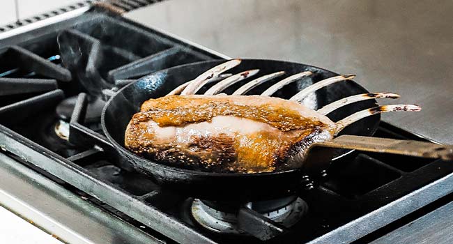 browning a rack of lamb in a pan