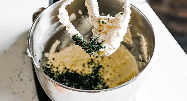 adding herbs to whipped butter