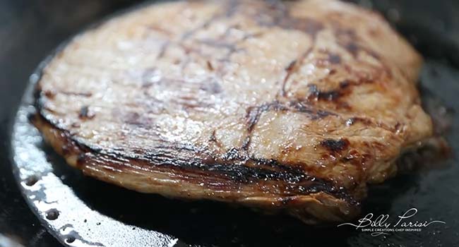 searing flank steak in a pan
